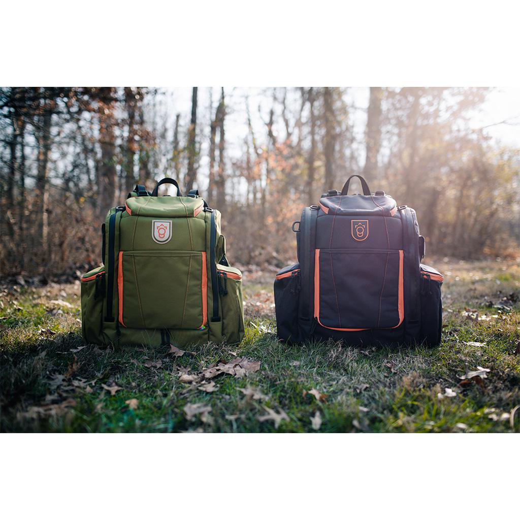 Squatch Legend 3.0 Disc Golf Backpack w/ Cooler Disc Golf Bag Forest-Orange  and Charcoal-Salmon bags sitting side by side on the ground