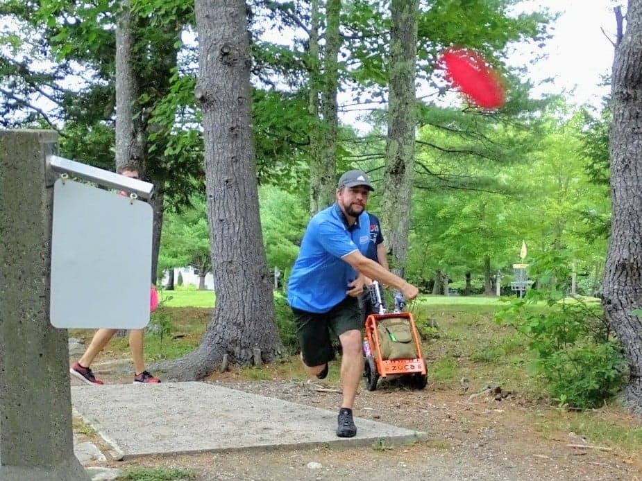 nate sexton throwing a roller off tee 16 of the eagle falcon course at sabattus disc golf