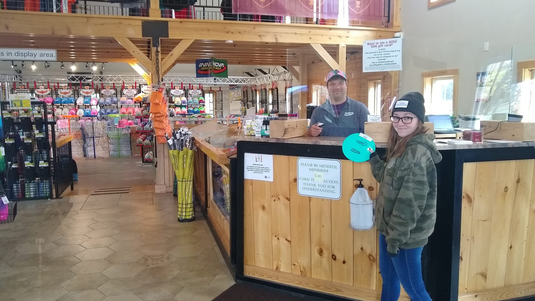 Andrew Streeter and Amber Grenier stand at the front desk inside Sabattus Disc Golf Pro Shop in Sabattus, Maine.