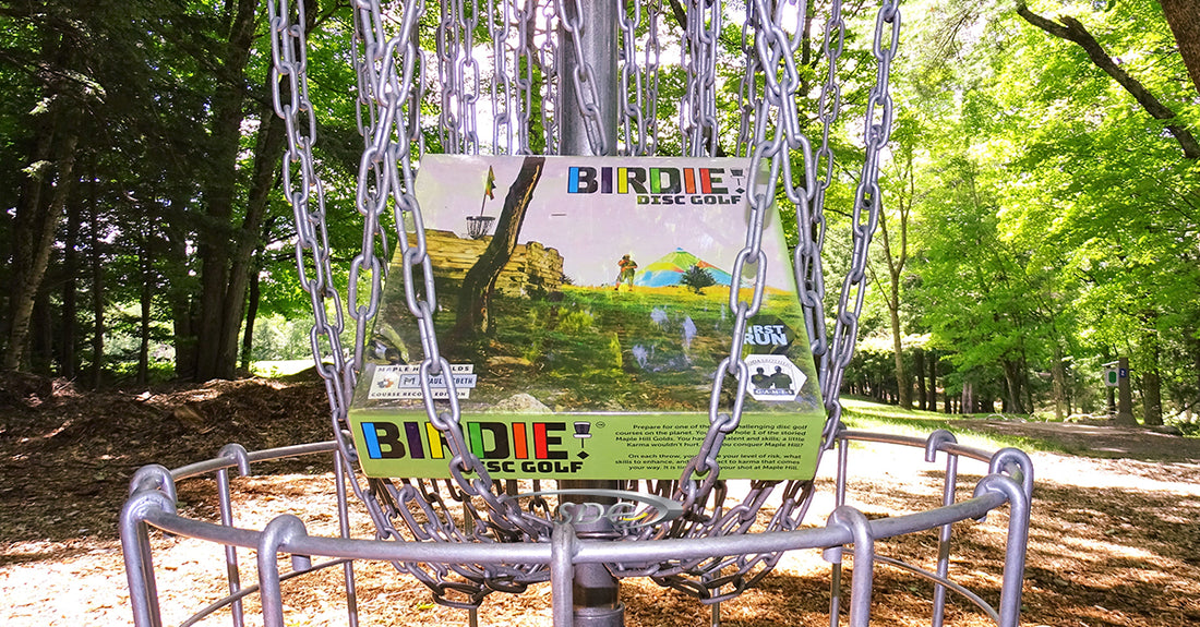 Birdie! board game hanging in the chains of a basket at sabattus disc golf