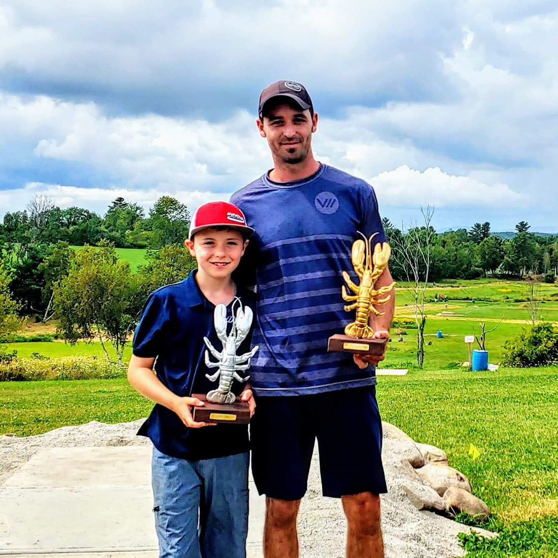 uriyah and kevin kelley with their lobster trophies at the maine state disc golf championship