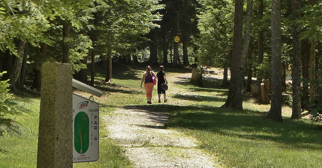 two disc golfers walking down the path of the eagle/ falcon course at sabattus disc golf