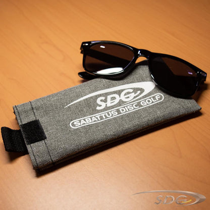 Sabattus Disc Golf Branded black sunglasses with Sabattus Disc Golf Branded Heathered Gray Sunglasses Sleeve on table