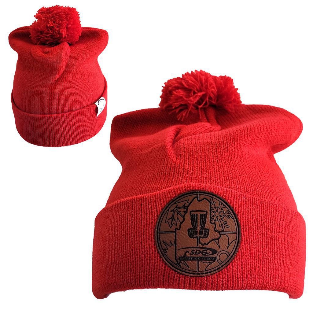 True Red Knit Pom Pom Beaning with SDG Sabattus Disc Golf Laser Engraved on leather patch that is sewn to the front of the hat, also a back view of the hat with the Rogue Life Maine logo on a small white tag sewn to the hat rim 