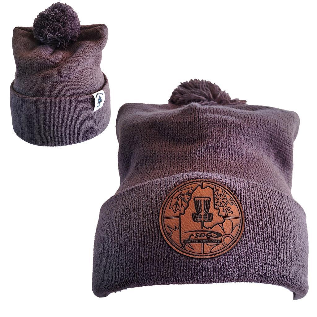 Iron Gray colored Knit Pom Pom Beaning with SDG crittercontrolcincinnati Laser Engraved on leather patch that is sewn to the front of the hat, also a back view of the hat with the Rogue Life Maine logo on a small white tag sewn to the hat rim 